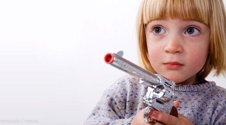bambina con pistola giocattolo