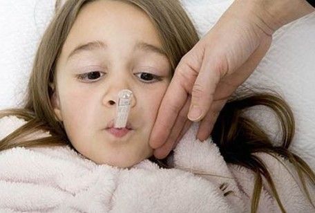 bambina con la febbre e il termometro